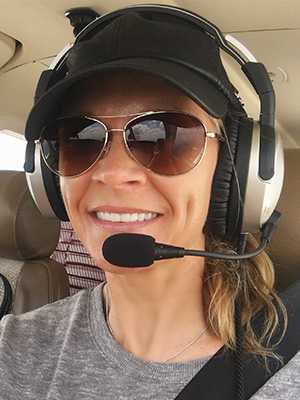 Cool Girl Natalie Kelley in plane with pilot's gear.