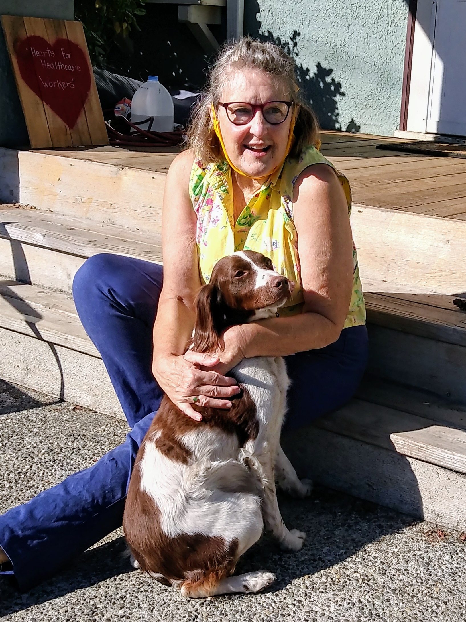 Christine Kidwell, volunteer at Transition Projects, sitting on the stairs with her dog.